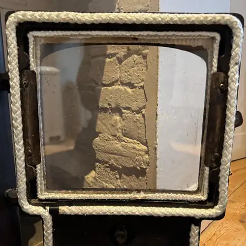 A wood burner with repaired door ropes