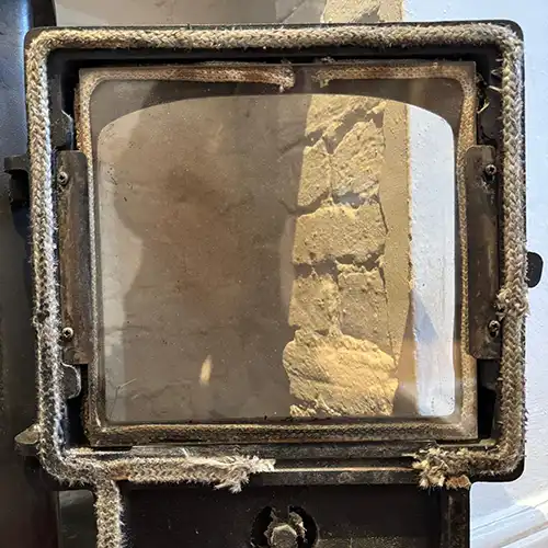 A wood burner with frayed door ropes